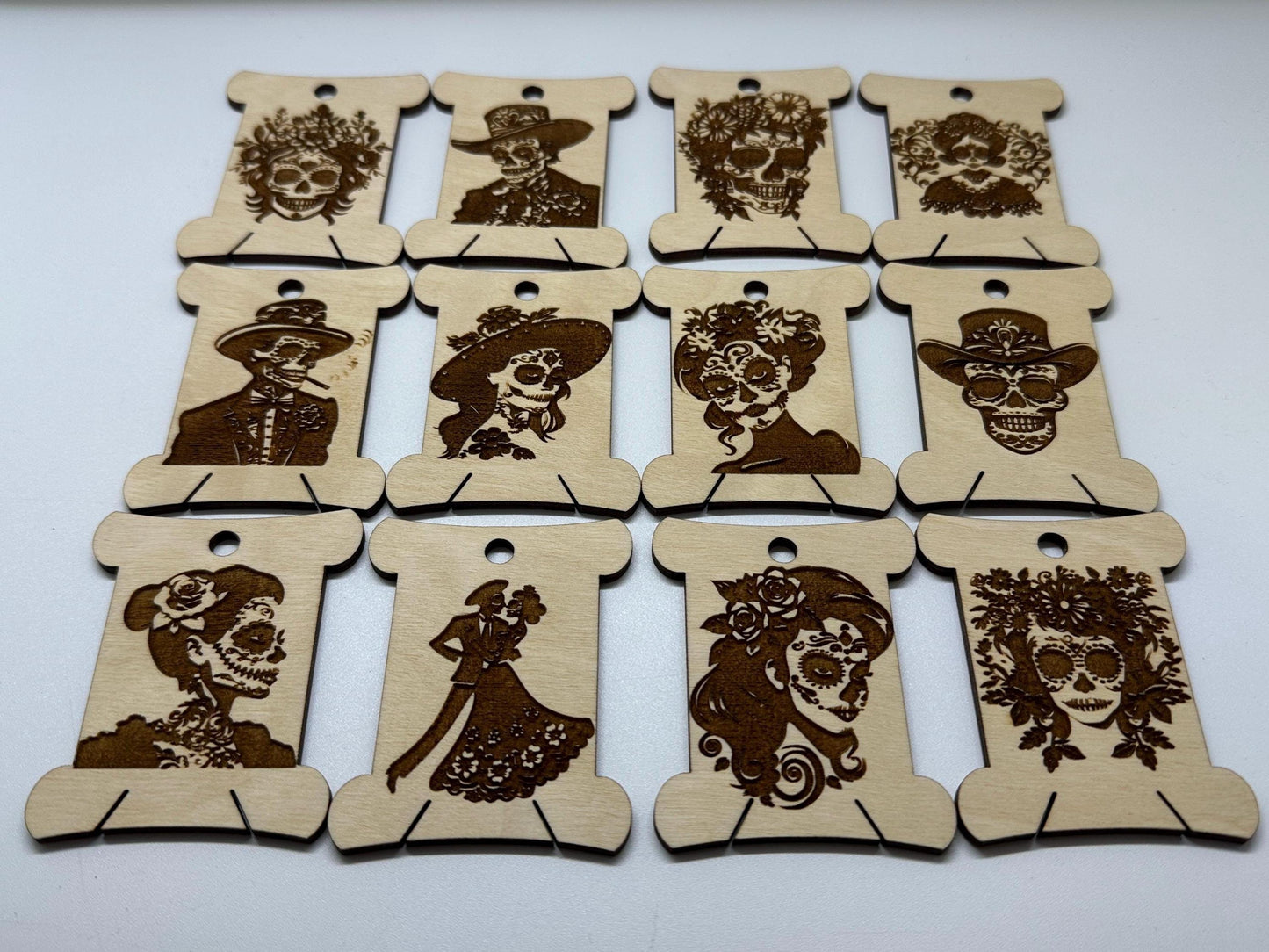 Set of wooden bobbins with laser-cut designs of faces on a white background