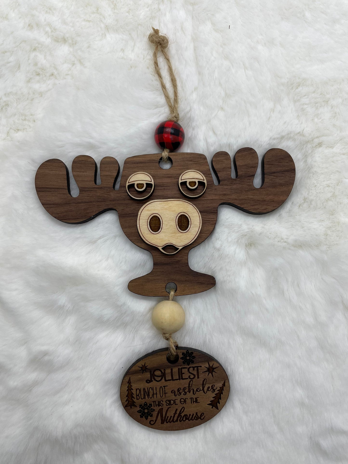 Wooden moose ornament with a tag on a white background