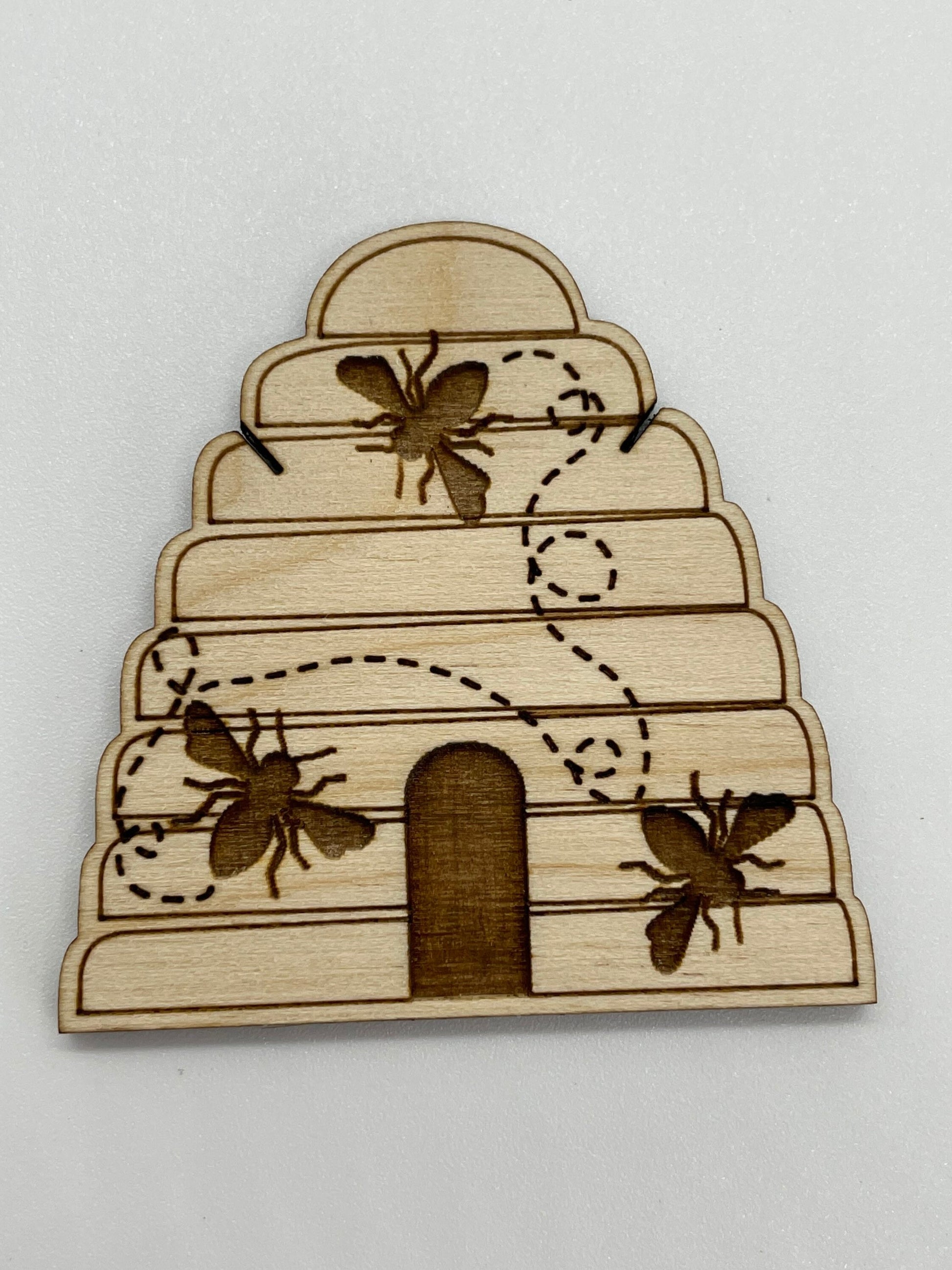 Wooden bee hive with laser-cut bees on a white background