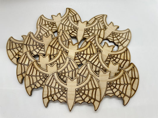 Wooden cutouts of bats and spider webs on a white background