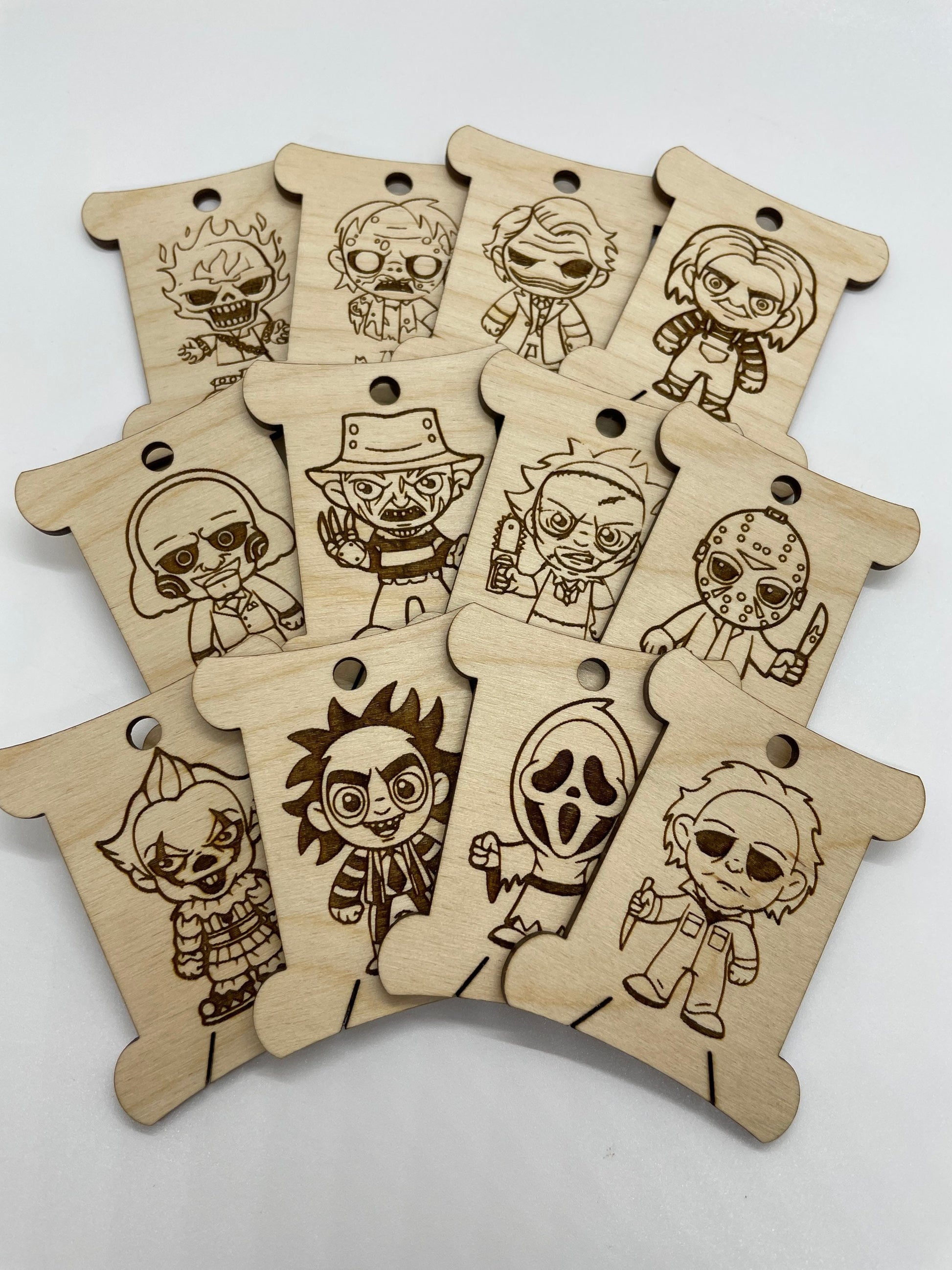 Set of wooden keychains with engraved character designs on a white background