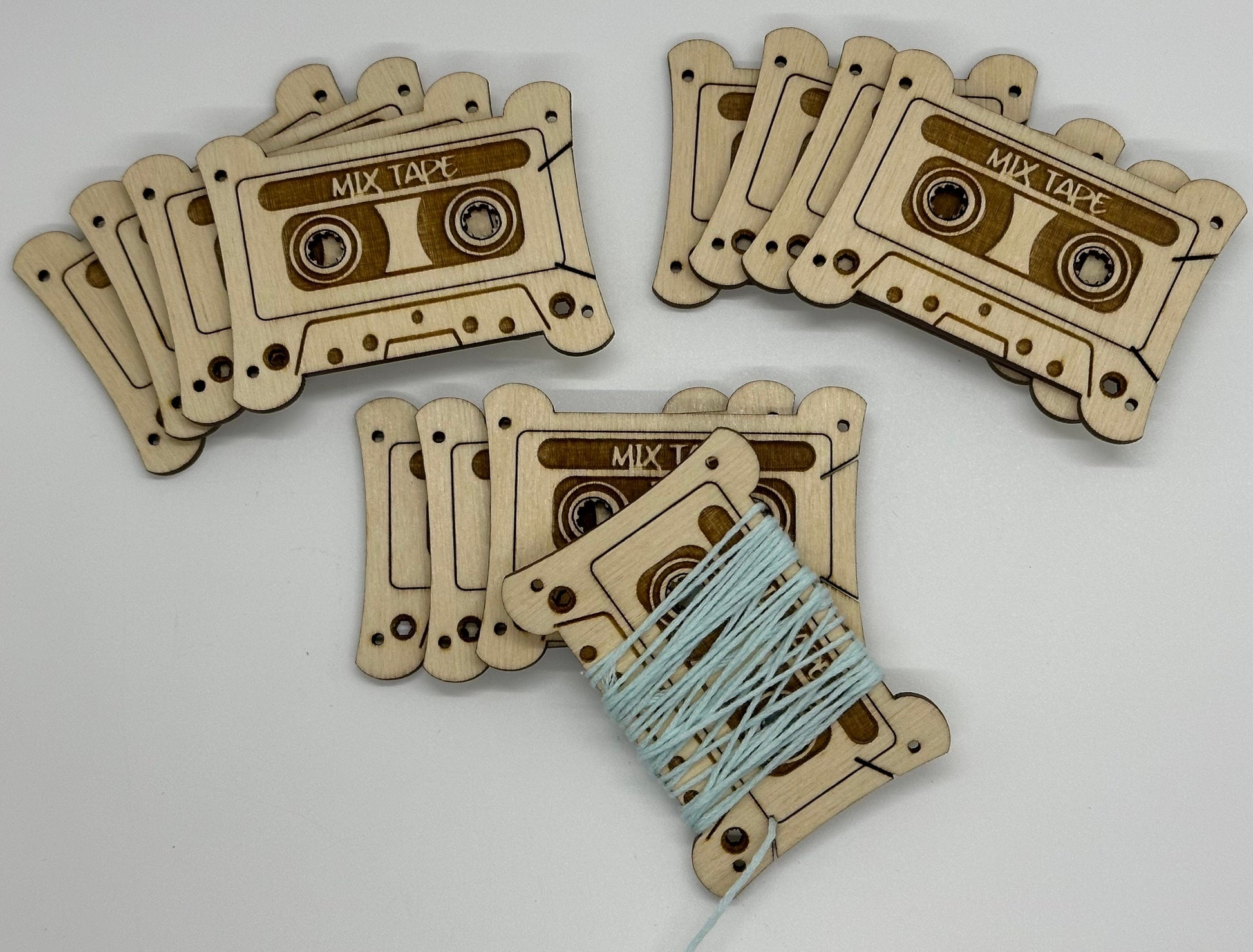 Wooden tape cassette bobbins with a string on a light gray background