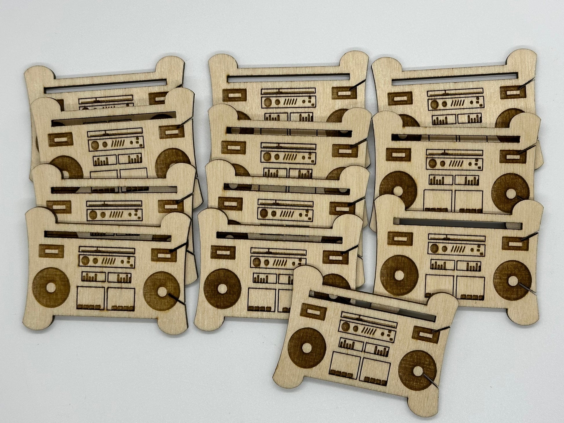 Set of wooden bobbins with retro radio and cassette tape designs on a white background