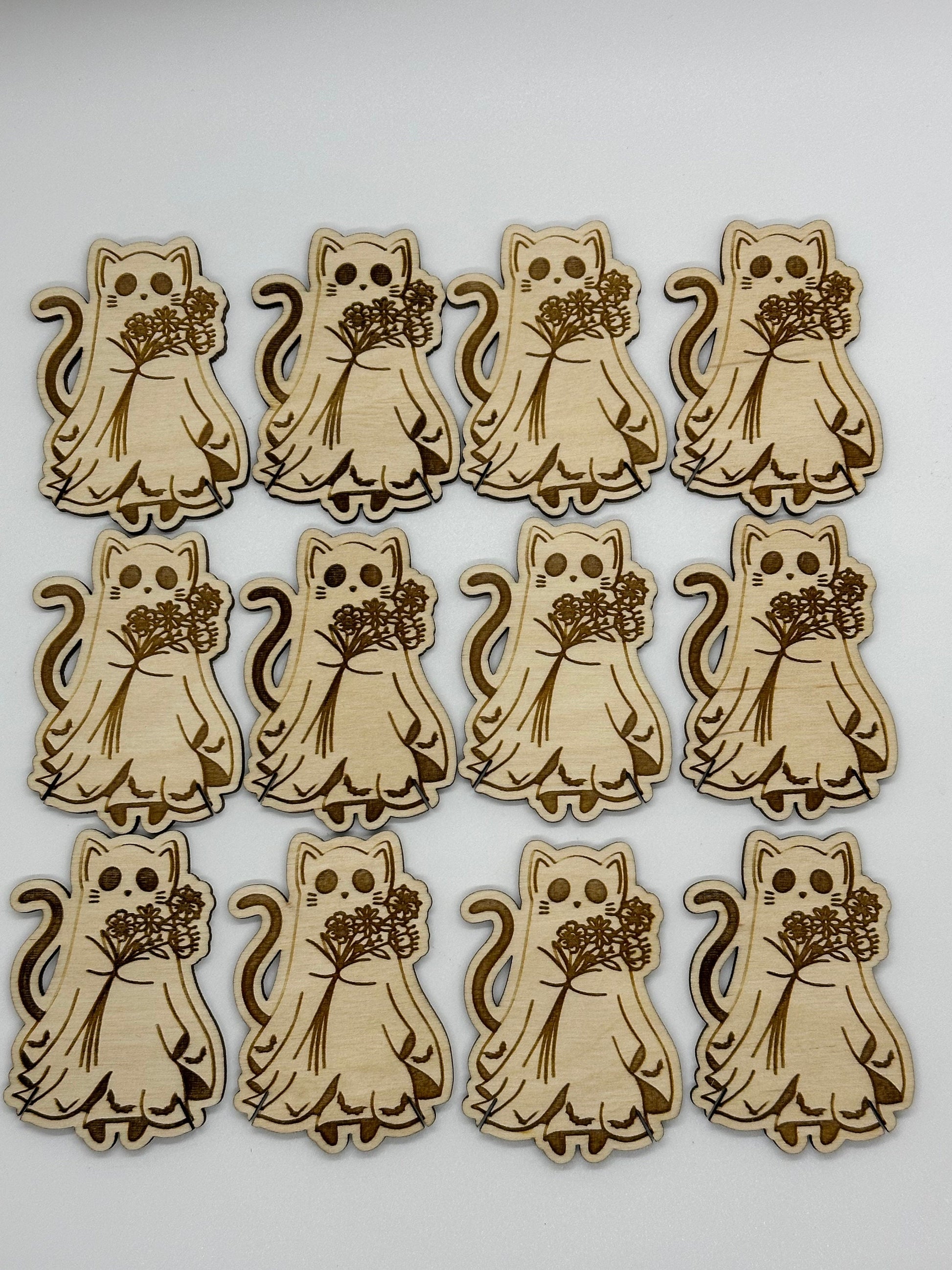 Set of wooden cat-shaped bobbins with floral bouquets on a white background