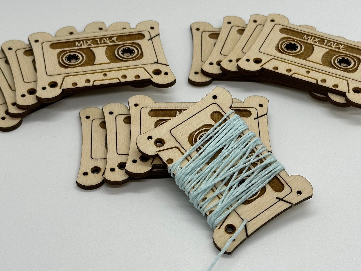Wooden cassette tape-shaped cards with string on a white background