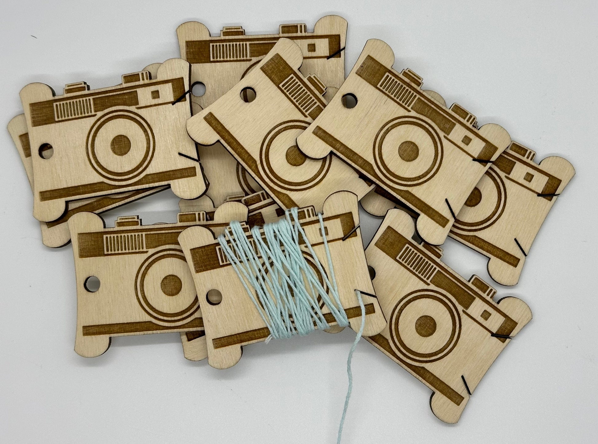 Wooden camera-shaped items with string on a white background