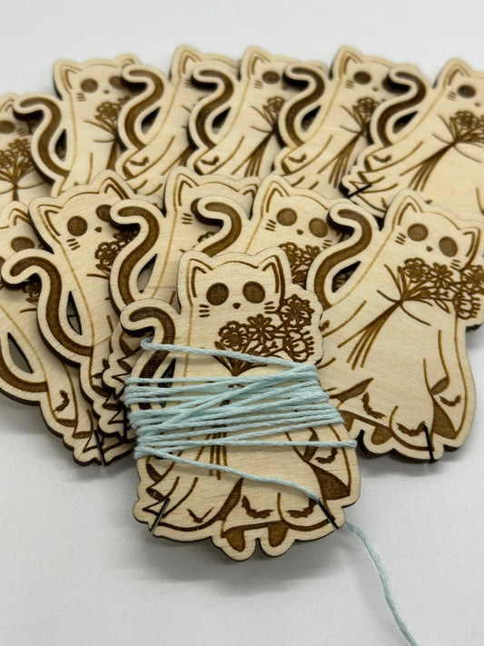 Wooden cat-shaped decorations with a string of blue beads on a white background