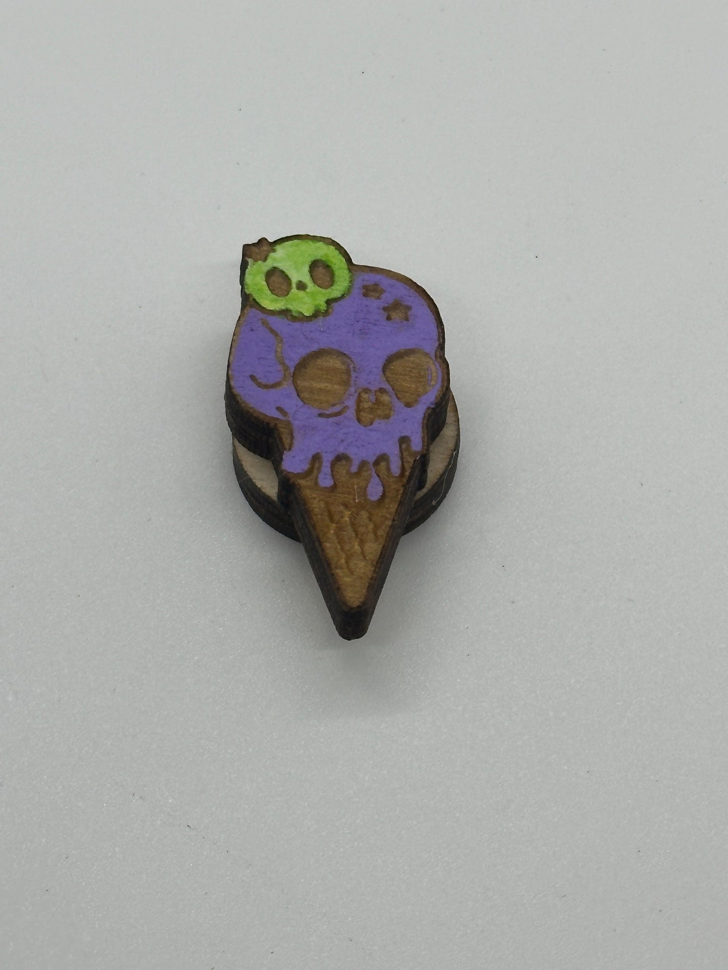 Colorful ice cream cone-shaped object with a skull design on a light gray background