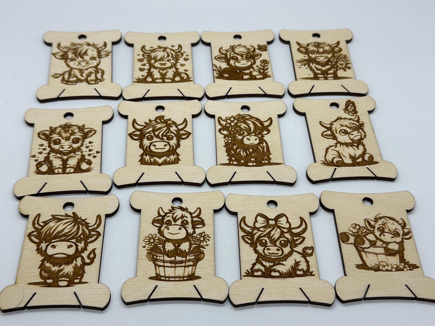 Set of wooden tags with engraved cow designs on a white background