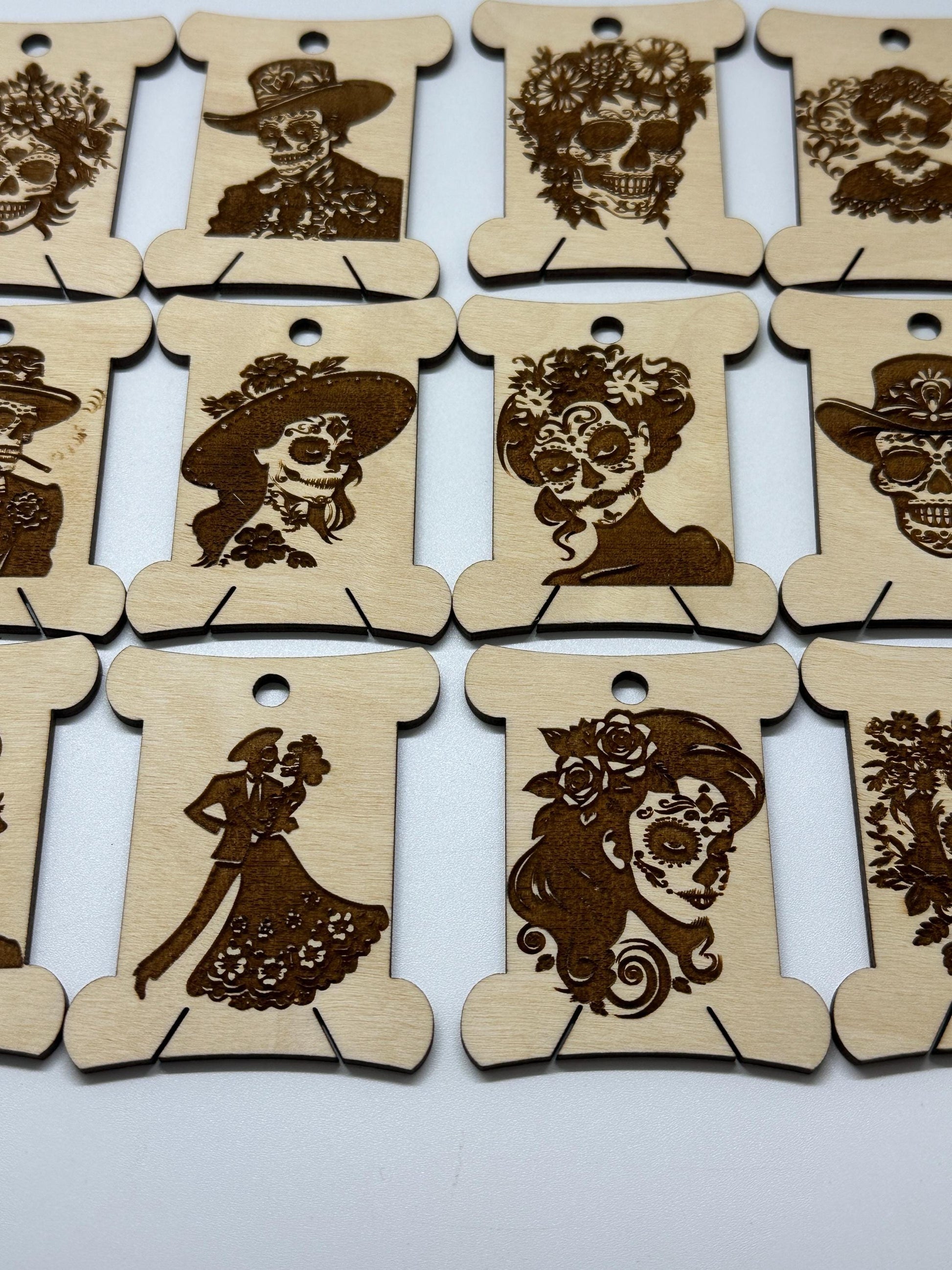 Set of wooden bobbins  with laser-cut designs on a white background