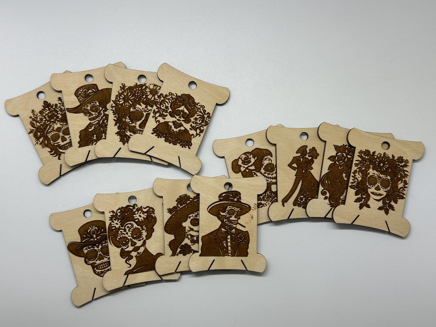 Set of wooden bobbins  with engraved designs on a white background