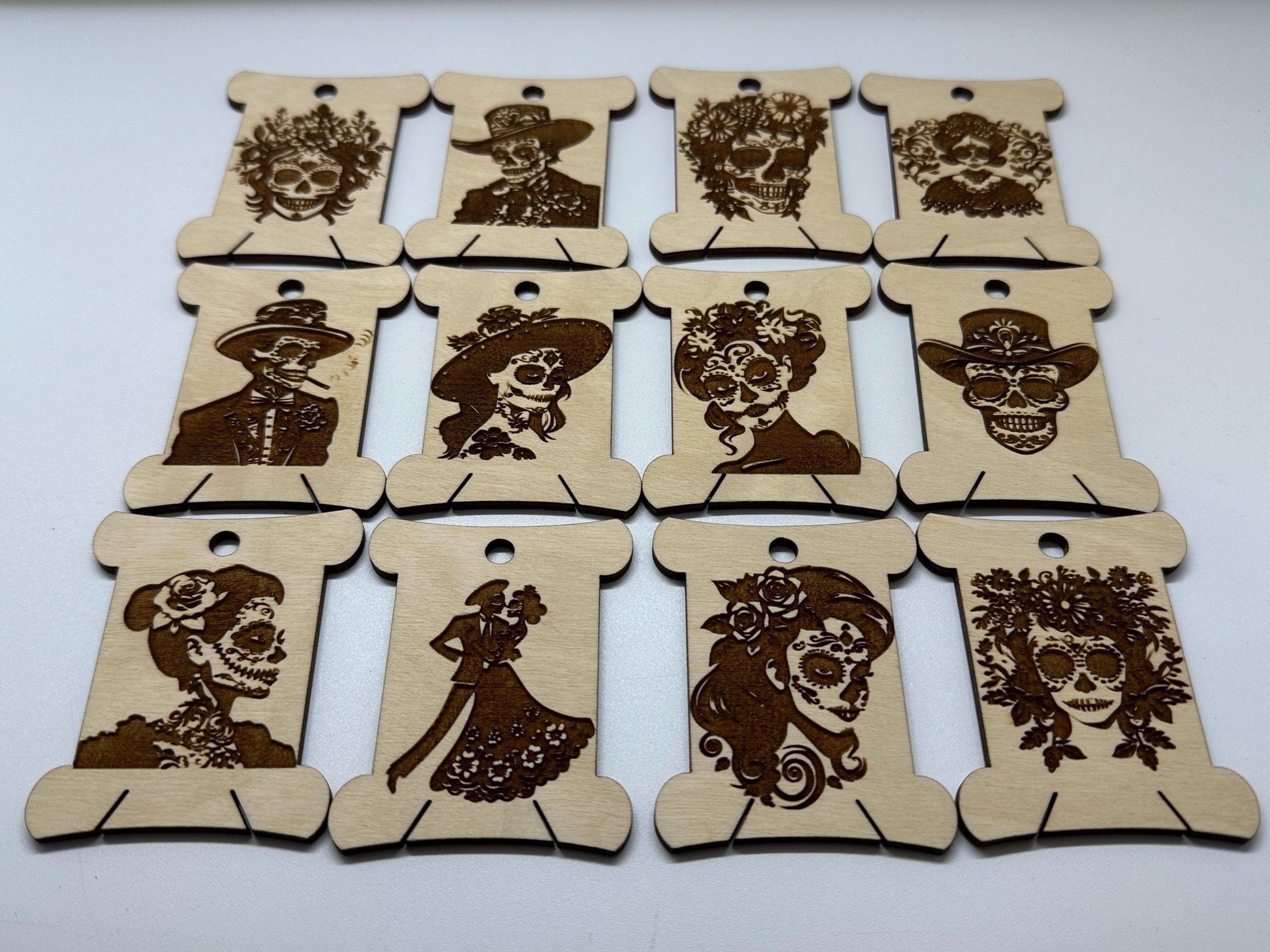 Set of wooden bobbins  with laser-cut designs of faces on a white background