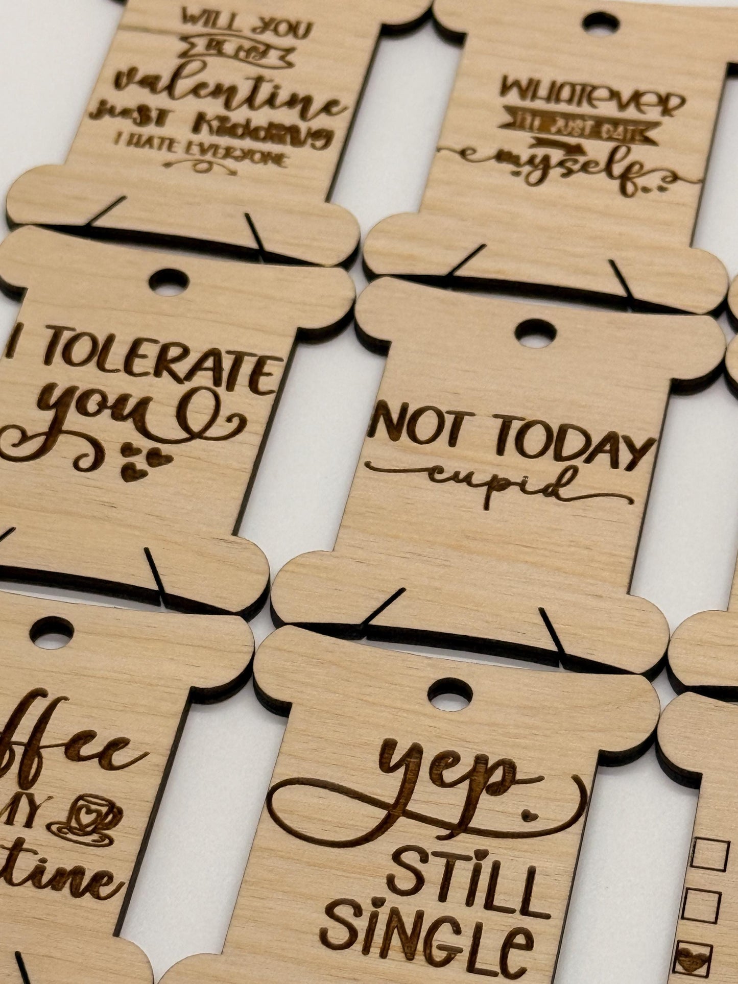 Wooden tags with humorous sayings on a white background