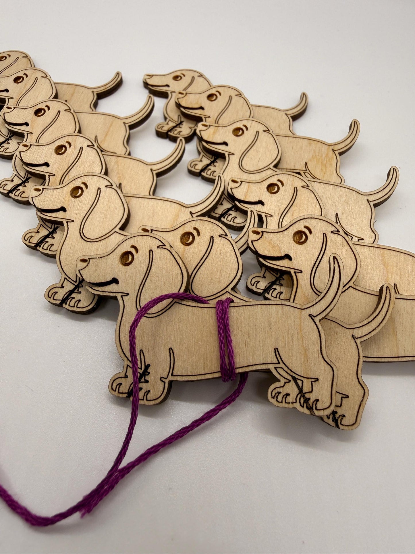 Wooden dog-shaped decorations with a string on a white background